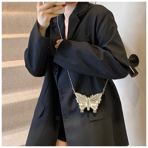 Détail d'un mini sac boîte en forme de papillon argenté orné de strass et d'une chaîne