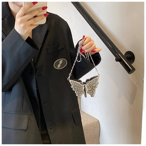 Sac de soirée papillon argenté avec strass et chaîne porté par un mannequin