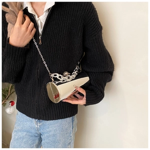 Close-up of silver cylinder mirror evening bag with pearl chain detail and metal strap