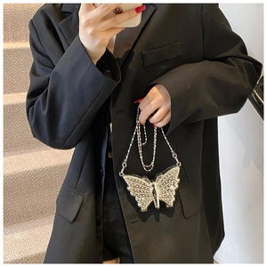 Détail de la pochette papillon argentée avec strass brillants et bandoulière chaîne