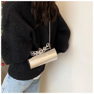 Mirror-finish silver cylindrical clutch bag with metallic chain straps shown on model