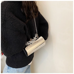 Macro view of silver mirror finish cylindrical bag with metallic chain detail