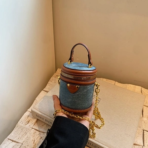 Mini denim bucket bag with leather trim and gold chain strap for stylish women