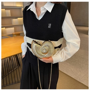 Detailed view of a gold nautilus shell clutch bag with metallic texture and chain strap