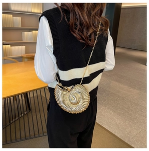 Detailed view of a gold seashell-shaped bag with a metallic finish and chain strap