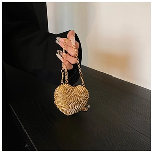 Detailed view of heart-shaped mini bag with sparkling rhinestones and gold chain