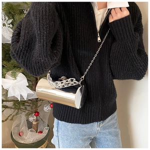 Chic silver cylinder bucket bag with mirror finish and stylish chain straps on a model