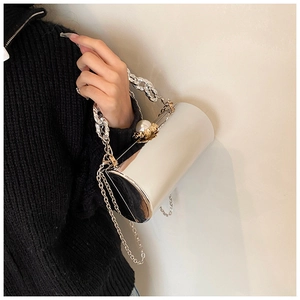 Close-up of silver mirror bucket bag featuring luxury pearl flower clasp and chain