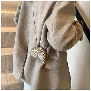 Elegante borsa in metallo a forma di nautilus argento con catena a sfere indossata da modella
