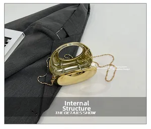 Detail of gold hard shell acrylic evening bag showing internal structure and organza gussets