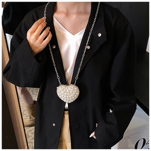 Detail of heart-shaped mini pearl bag with sparkling fringe and silver chain strap