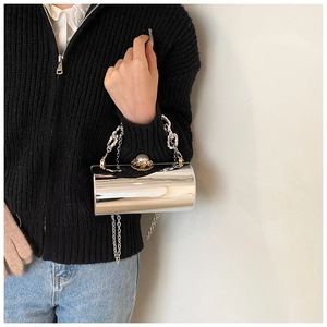 Detail of silver mirror cylinder evening bag with pearl top handle and chunky chain