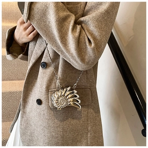 Mini borsa a catena in metallo argentato a forma di nautilus indossata da modella