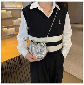 Detail of silver nautilus evening bag with spiral texture and metal chain strap