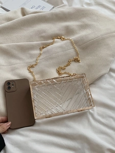 Detail of transparent acrylic crossbody bag featuring chevron geometric patterns and gold chain