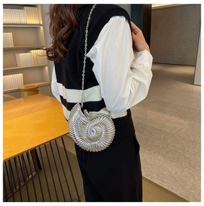 Close-up of silver seashell chain bag with spiral shell texture and metal strap