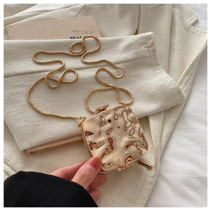 Detail van het metallic mini box tasje met glanzend getextureerd oppervlak en ketting.