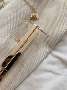 Detailed close-up of high-quality golden hinges and clear acrylic on small box bag