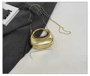 Detailed view of glossy gold metallic evening clutch with moon handle and bead chain