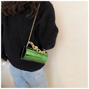 Fashion green acrylic cylinder bag with gold chain strap shown on black knit sweater