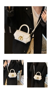 Close-up of white leather handbag with gold metal clasp and detachable strap detail