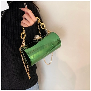 Detail of green acrylic mirror cylinder bag with gold chain and large pearl ornament
