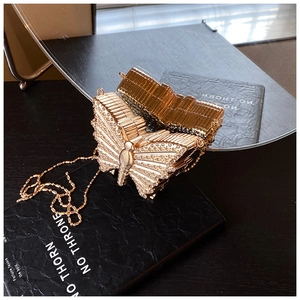 Détail du sac de soirée papillon avec strass étincelants et chaîne dorée élégante