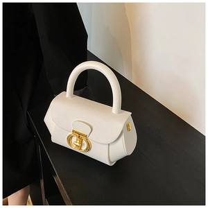 Detail of white leather texture and gold interlocking metal buckle on a sleek handbag