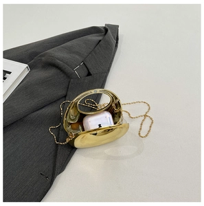 Detail of gold oval evening clutch showing interior storage for small accessories