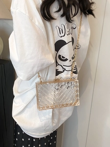 Detail of transparent acrylic crossbody bag with V-shaped texture and gold chain strap