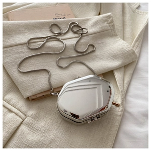 Detailweergave van de metallic mini box crossbody tas met zijn unieke achthoekige vorm.