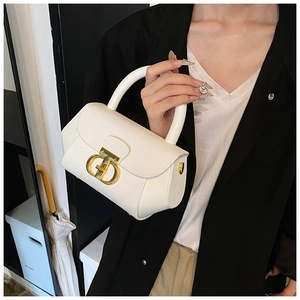 Detailed view of cream leather handbag featuring a gold interlaced metal logo buckle