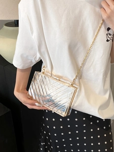 Detailed view of acrylic box bag featuring V-cut texture and elegant gold chain strap