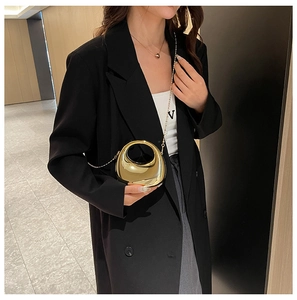 Close-up of golden crescent moon acrylic evening bag with metallic chain strap for women
