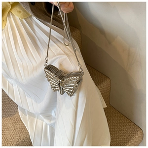 Détail d'un sac de soirée papillon argenté avec strass brillants et bandoulière chaîne