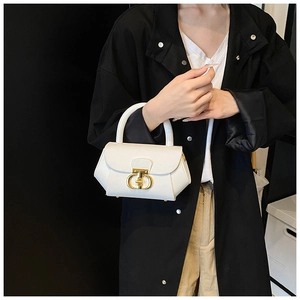 Close-up of white geometric leather handbag featuring a gold double-ring clasp and handle