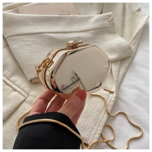 Gedetailleerd overzicht van de elegante metalen geometrische clutch met gouden ketting.