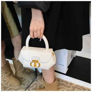 Detail shot of the white leather handbag featuring a vintage gold CD-style buckle
