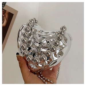 Dettaglio borsa a cuore argento metallizzato con manico di perle e tracolla