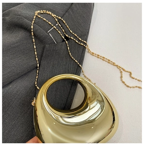Detailed view of luxury gold electroplated acrylic moon bag with circular handle and bead chain