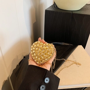 Sparkling heart-shaped clutch bag with amber rhinestones and gold chain strap