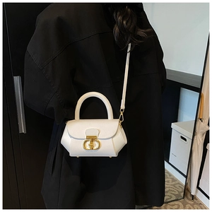 Detail of white leather handbag featuring gold D-shaped buckle and sturdy top handle