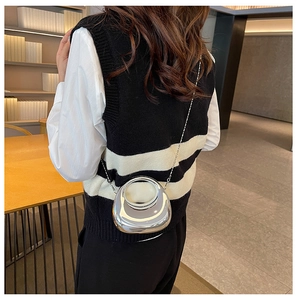 Silver mirror acrylic crescent bag with round handle and metal chain shown on model