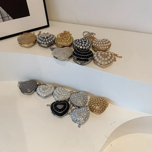 Sparkling heart-shaped evening clutch bag with pearls and rhinestones on display