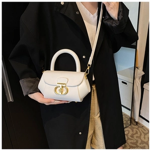 Close-up of minimalist white leather crossbody bag featuring a gold metal twist lock