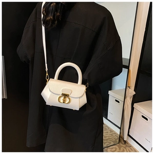 White trapezoidal leather shoulder bag featuring prominent gold circular ring hardware