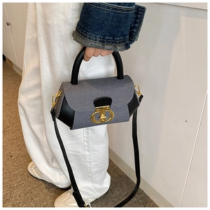 Detail of blue and white striped fabric with black leather trim and gold metal buckle