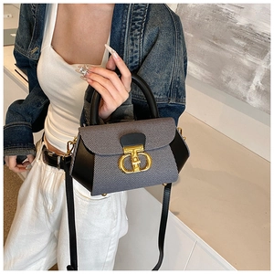 Detail of a chic striped crossbody bag featuring a golden metal buckle and leather strap