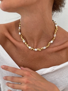 Detailed view of fashionable CCB pearl necklace with irregular gold beads on clavicle
