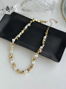 Detail of gold-tone irregular beads and white faux pearls on a minimalist necklace